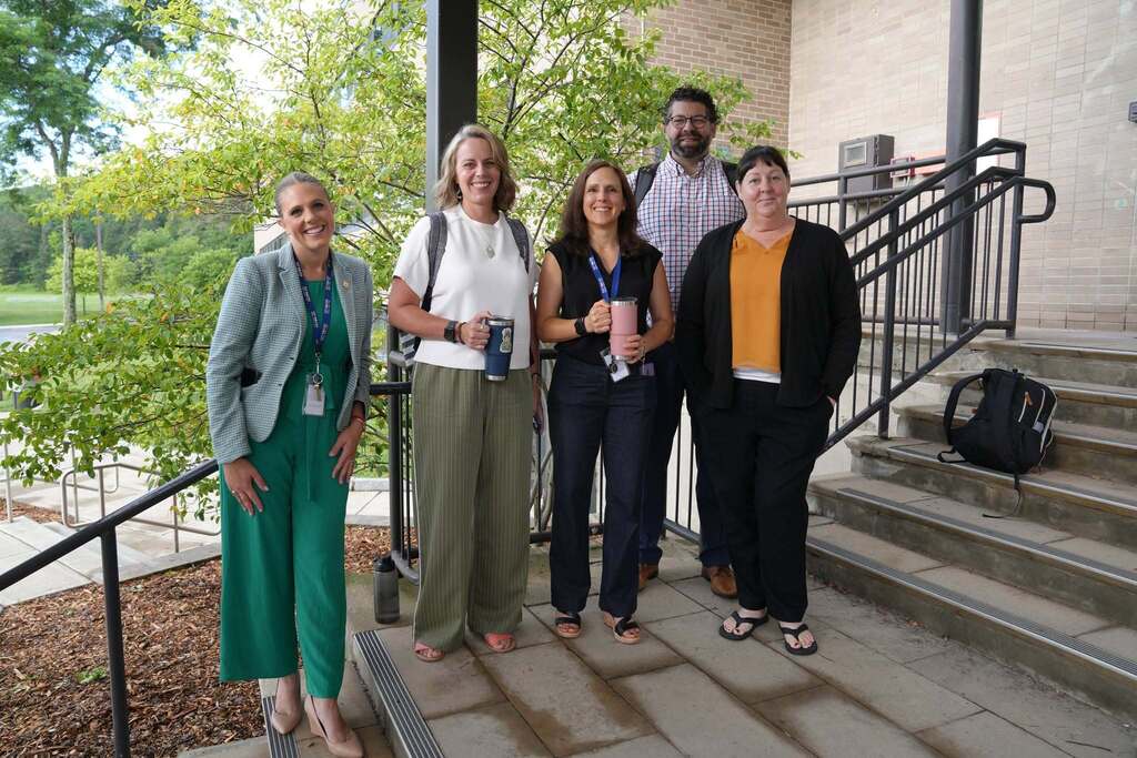 Educational leaders gather outside the conference venue before sessions begin, enjoying coffee and conversation.