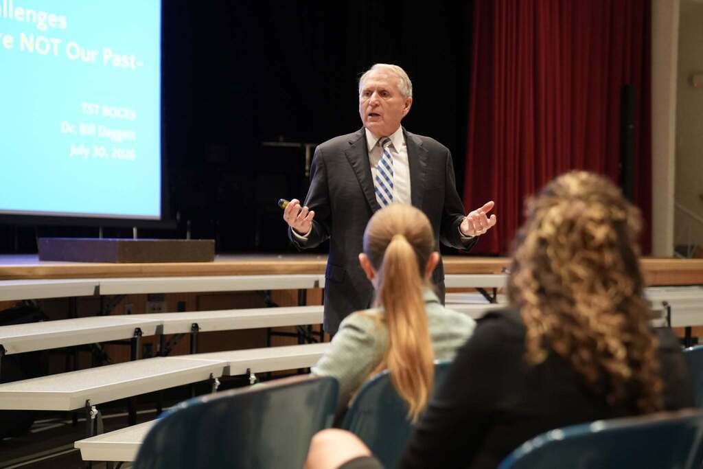 Dr. Bill Daggett speaks to conference attendees from the front of the auditorium during his keynote presentation on AI and educational leadership.
