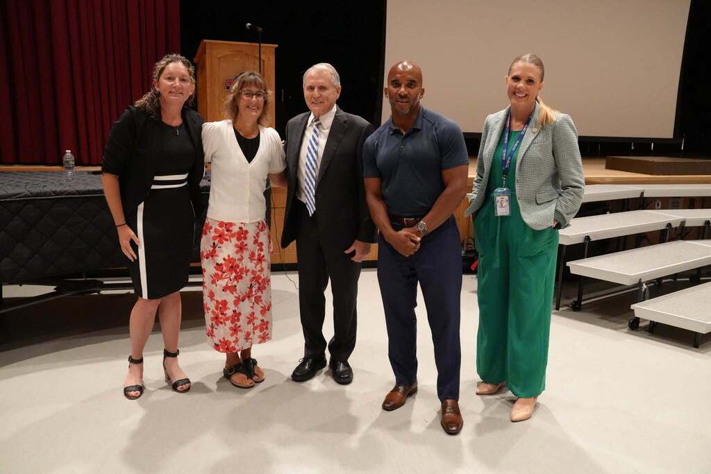 Conference Organizers pose for a group photo with keynote speaker Dr. Bill Daggett on stage at Groton Central School District.