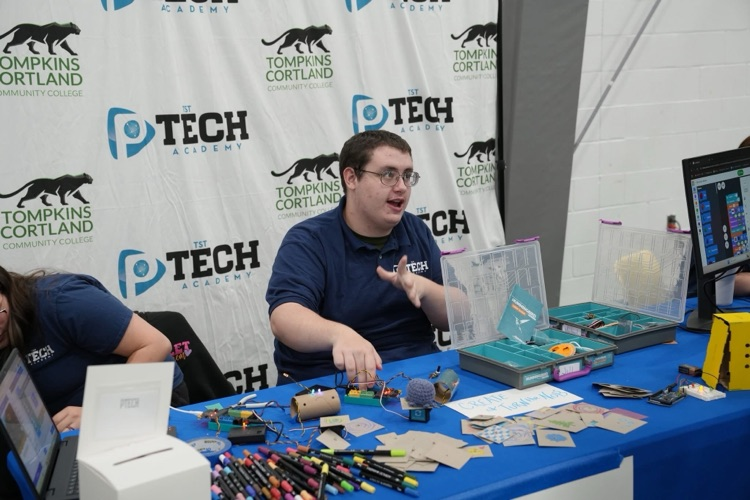 high school student from TST P_TECH talks with others at the interactive P-TECH booth at the "How It's Made" Expo at Tompkins Cortland Community College. 