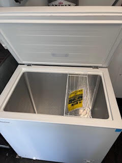 New chest freezer with open lid installed inside the food trailer for frozen food storage.