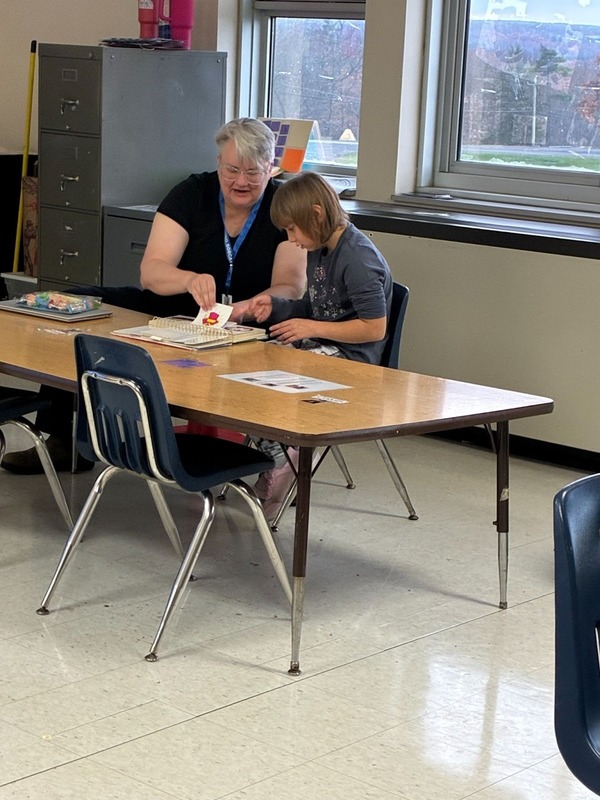 Student reading with teacher in Foundations program