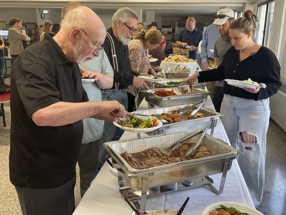 families in a food line filling their plates