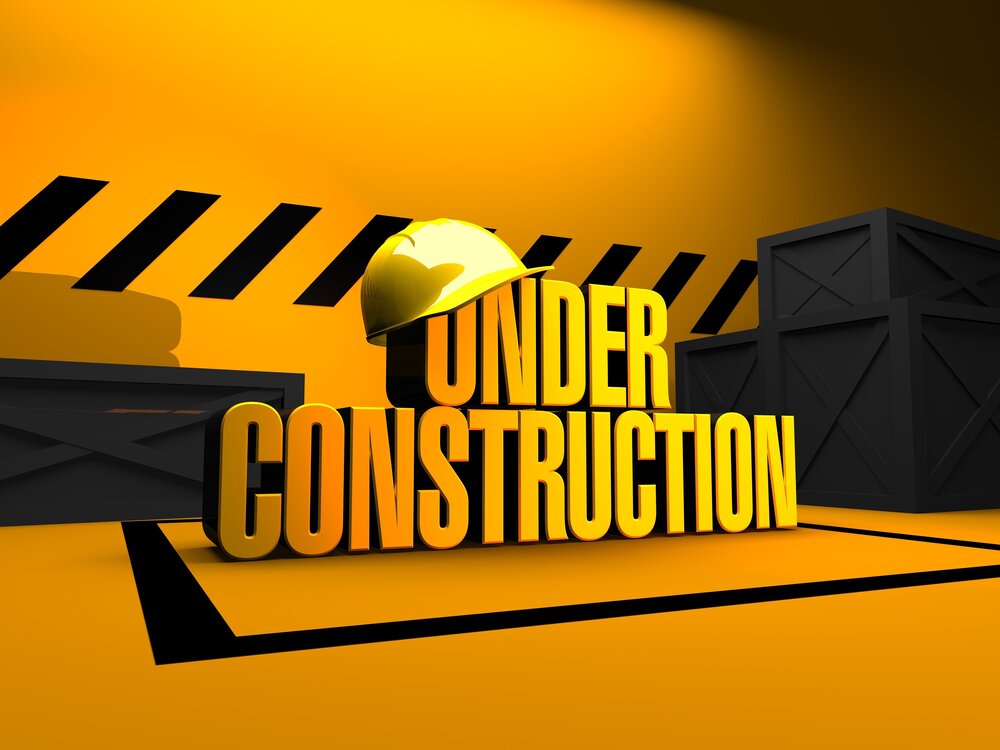 Under construction with hard hat balancing on the words