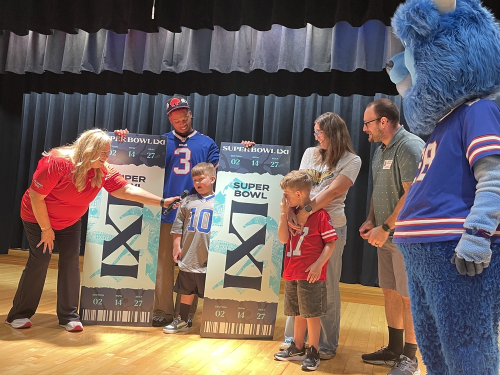student answers questions surrounded by giant superbowl tickets, damar hamlin, billy buffalo and family