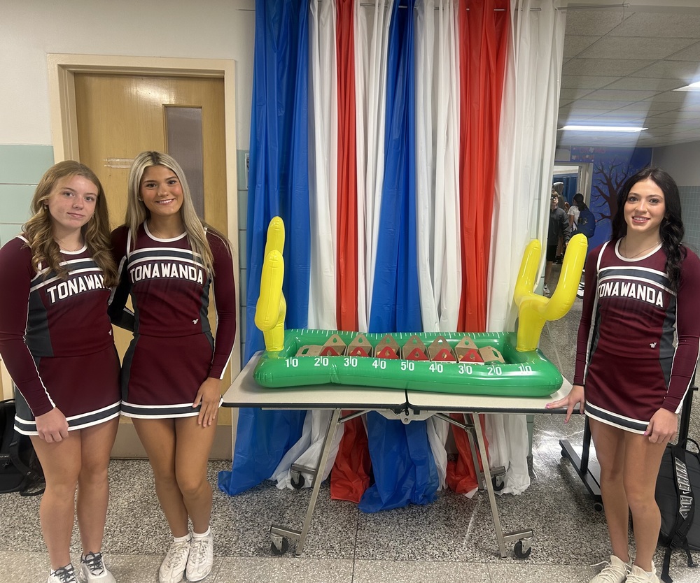 cheerleaders pose with inflatable football stadium
