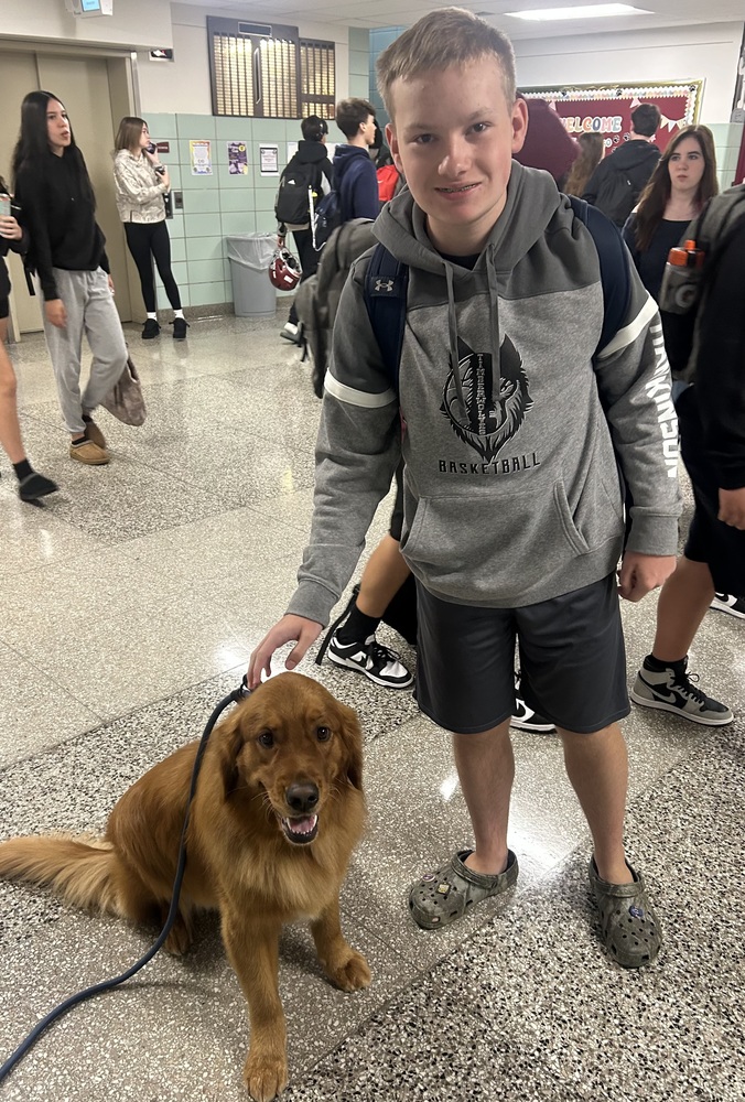 maverick and student pose together in hallway