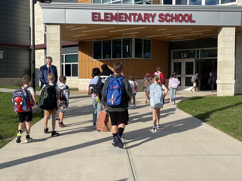 assistant principal greets students as they walk in the door