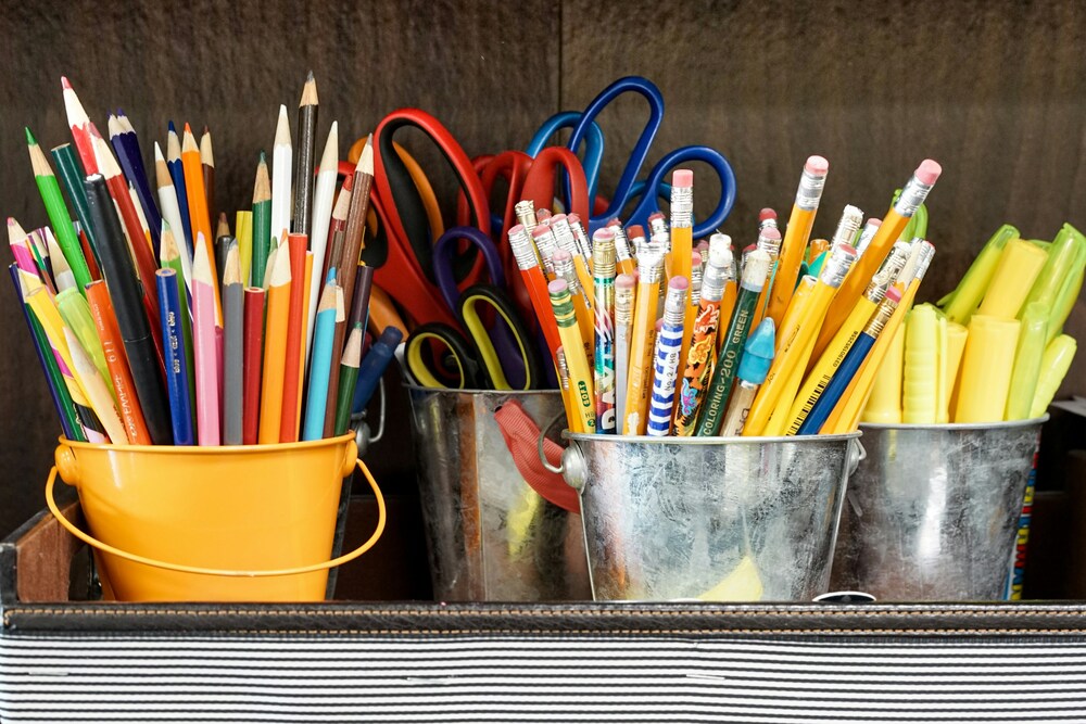 pencils, scissors and colored pencils in pails
