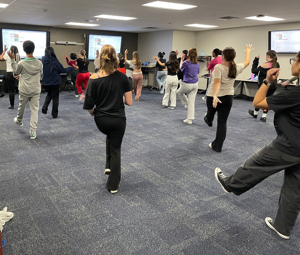 students learning a group dance together