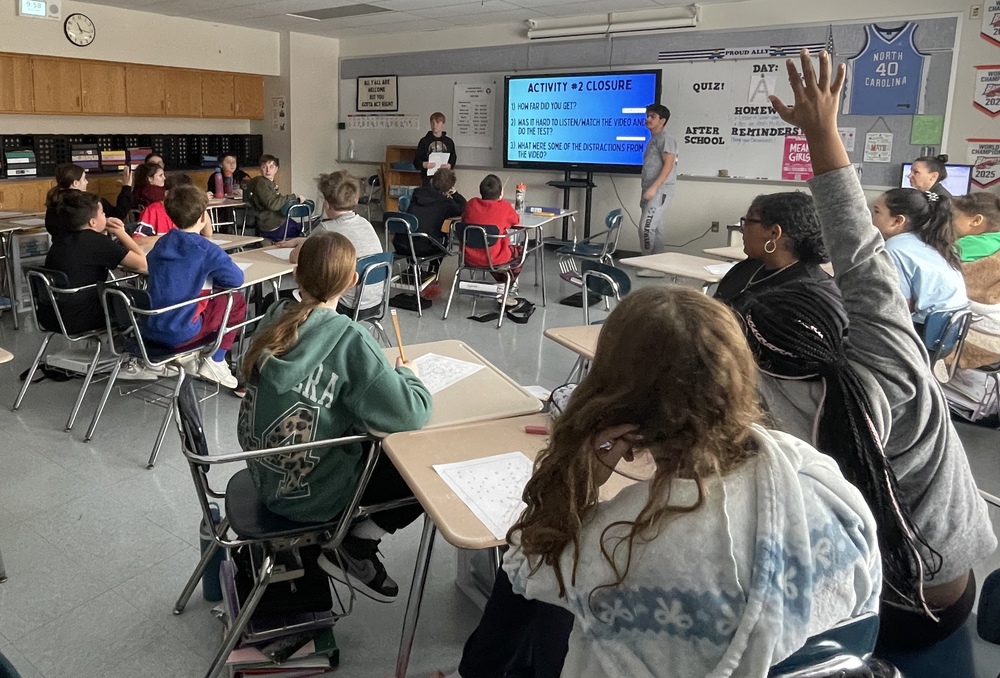 students in a classroom facing the front smart board