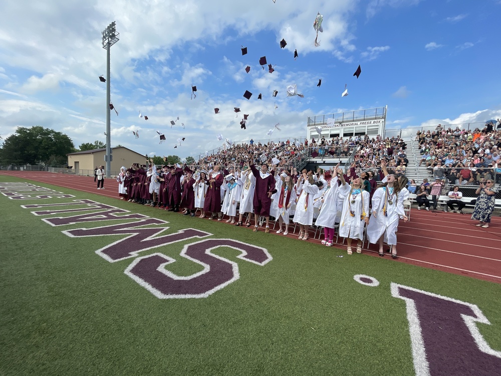 graduates throw caps in the air
