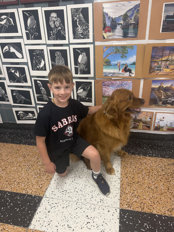 student kneeling and posing with dog