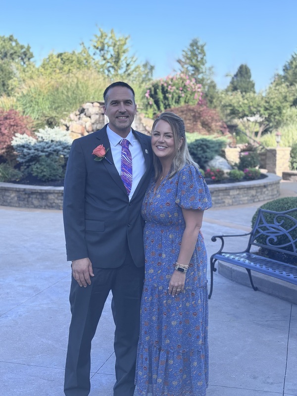 board president poses with wife outside