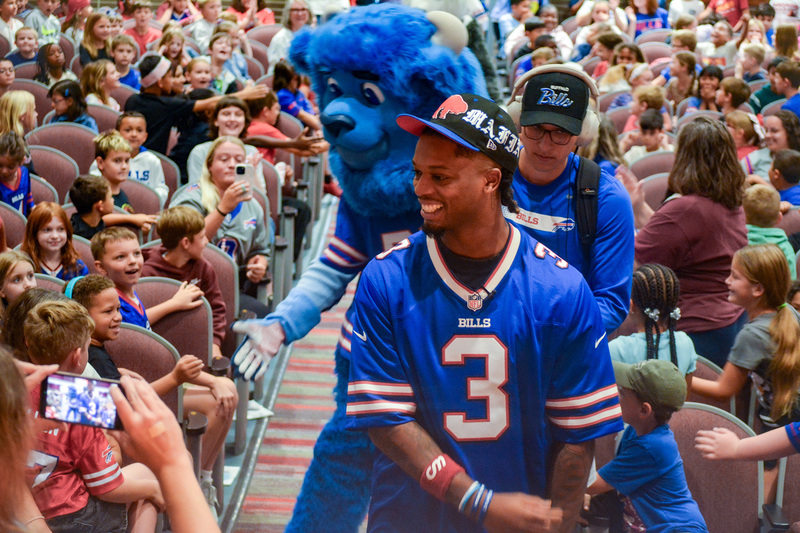 damar hamlin and bill buffalo walk down aisles of auditorium to cheering kids