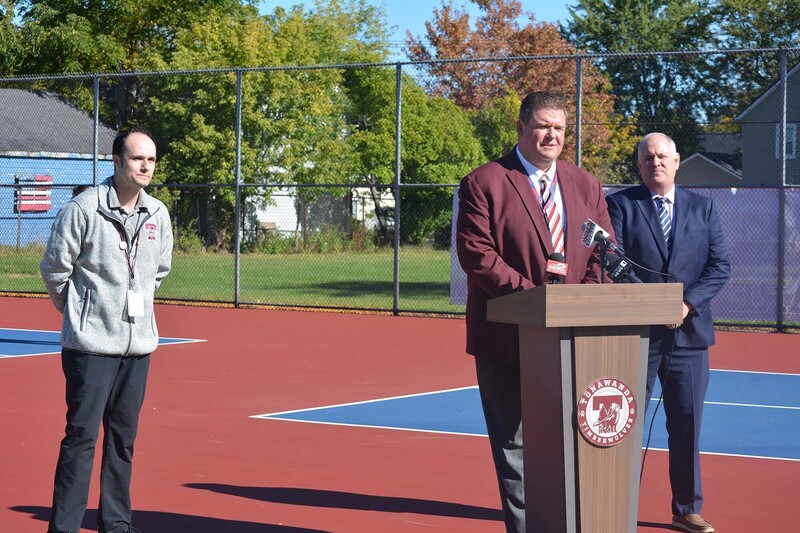 superintendent at podium with asseblyman and athletic director behind him