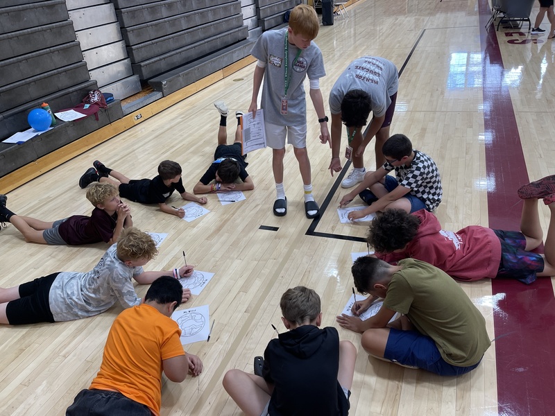 students work on gym floor in a circle
