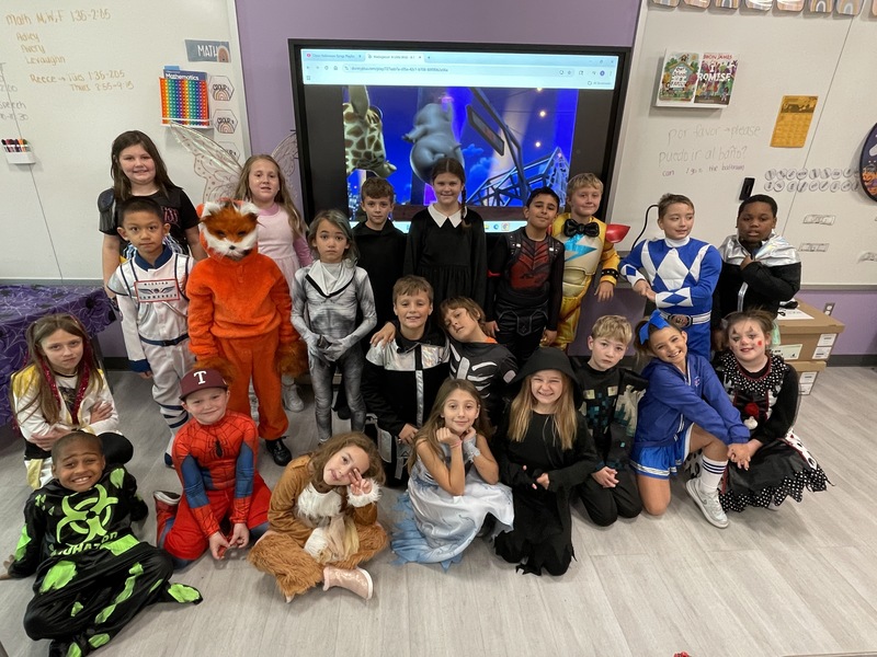 students pose in costume in their classroom
