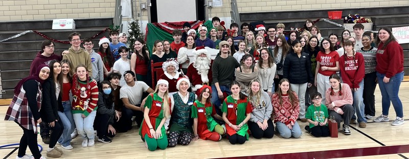 students and staff pose at christmas for kids