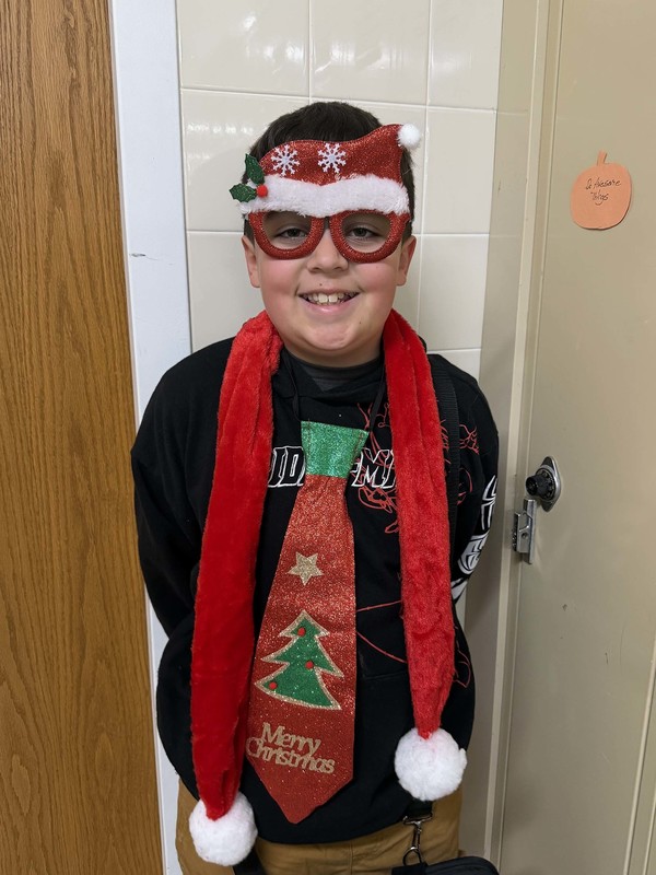 student poses in christmas sweater