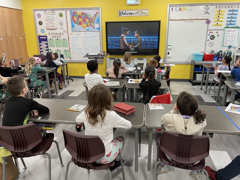 students sit at their desks watching the polar express