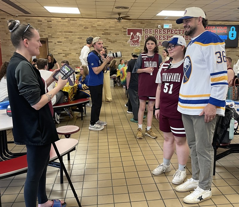 former buffalo sabre takes picture with ths student