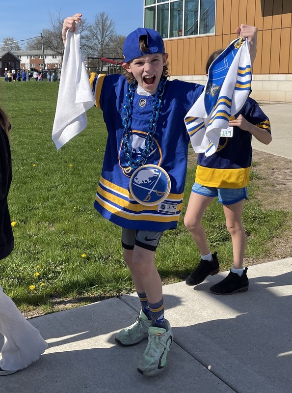 student yells at camera while waving sabres towels