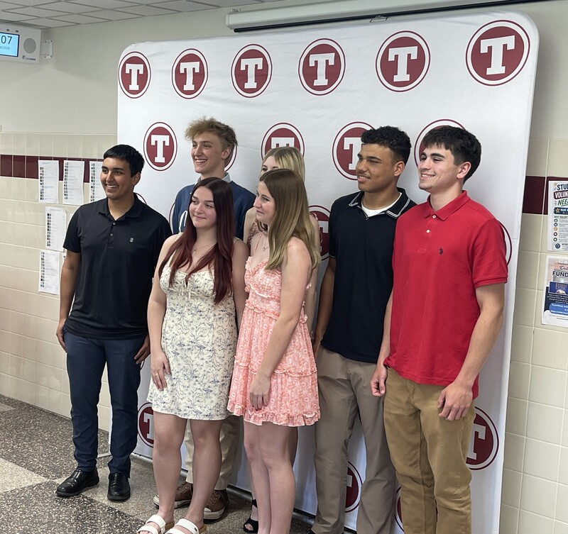 Students pose in front of Tonawanda logo backdrop
