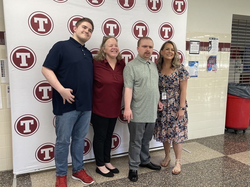 Students and staff pose in front of Tonawanda logo backdrop