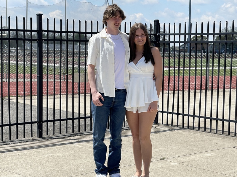 Students pose outside of football field