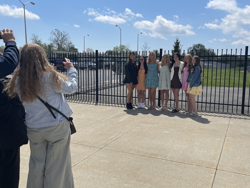 parents take photos as Students pose outside of football field