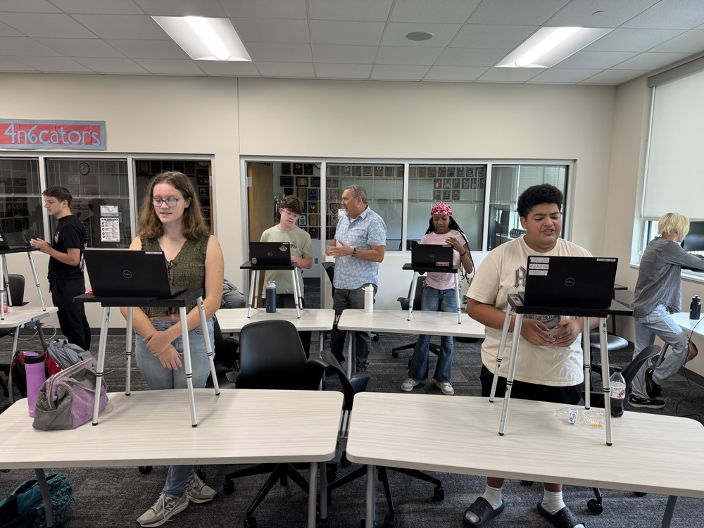 debate students stand at portable podiums practicing their speaking skills