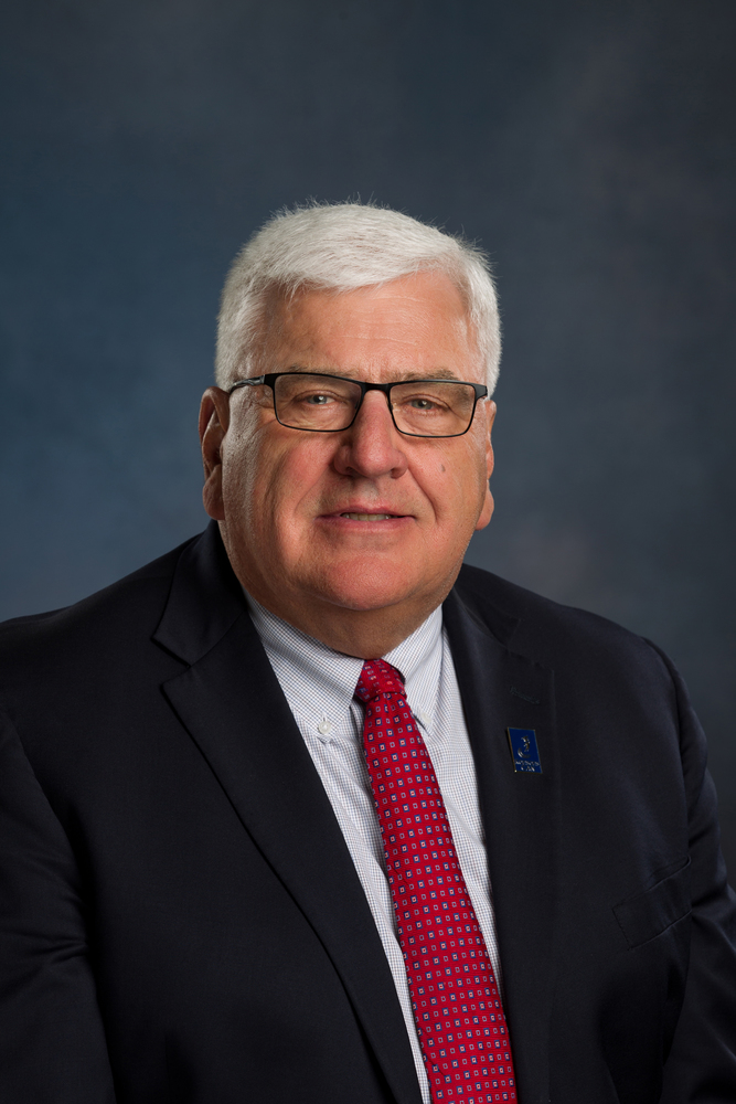 Loren Feldkamp headshot: white shirt, red tie, black suit coat