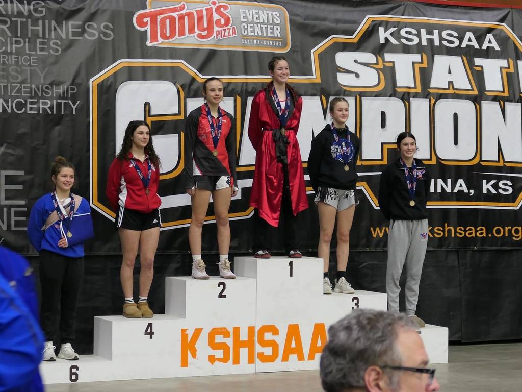 Stella Bradley stands on the first place podium spot