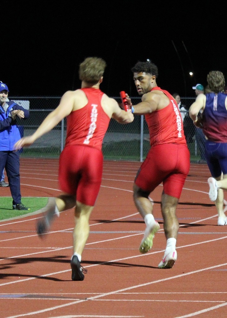 boys relay hands off the baton