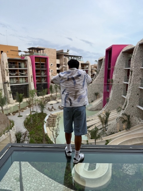 Ivan Franco looks out over a hotel balcony, the balcony floor is glass