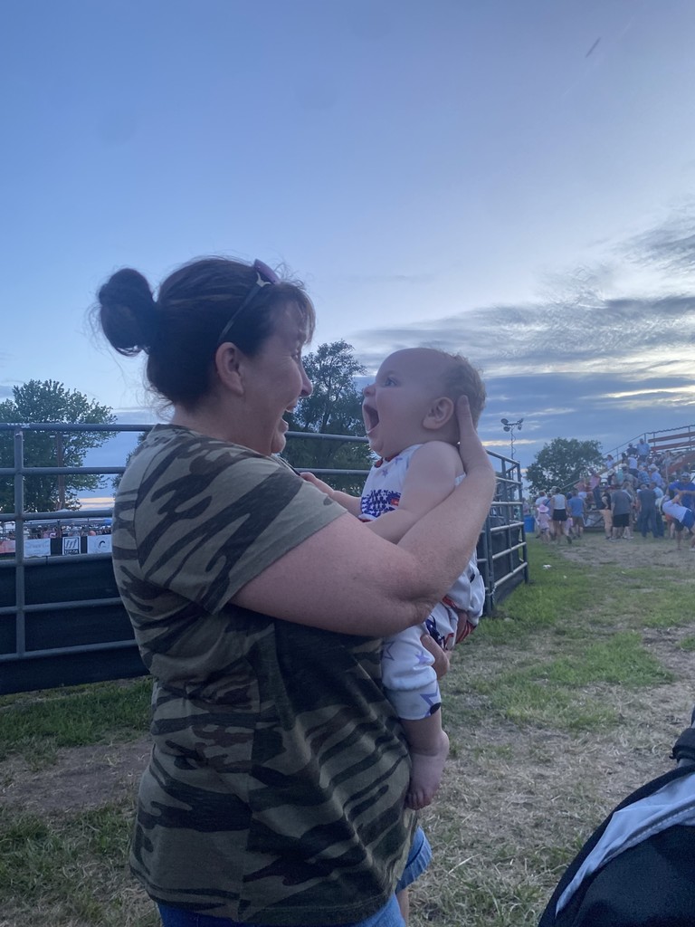 Nicole Martin wearing a black and green stripe top, holding her granddaughter Willow, wearing a red white and blue onesie