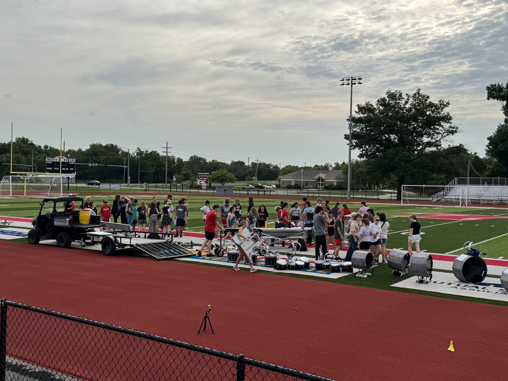 marching band members on the football field getting ready to practice