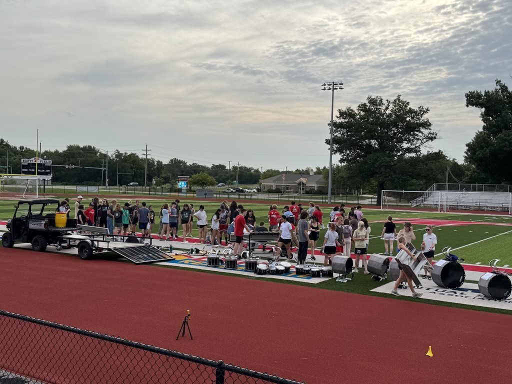 marching band members on the football field getting ready to practice