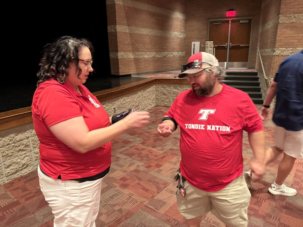 TES assistant principal hands a years of service pin to Dan Makin, a THS custodian