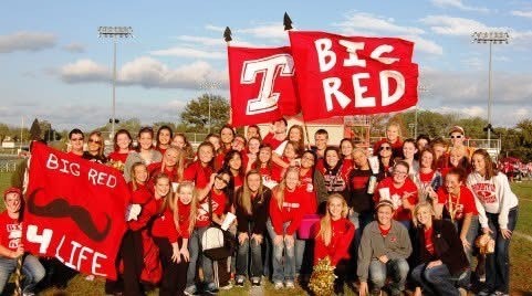 high school students wearing red shirts and waving red banners with white Tongie T, the words Big Red, and Big Red 4 Life on them