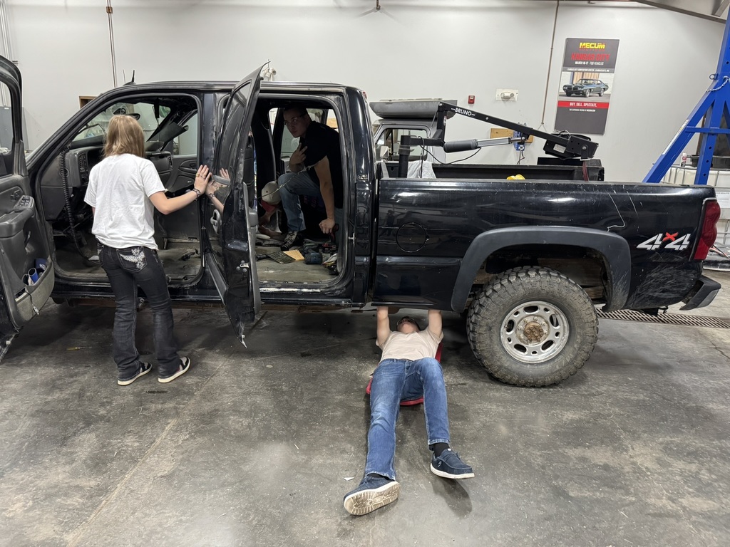 students working on a black truck