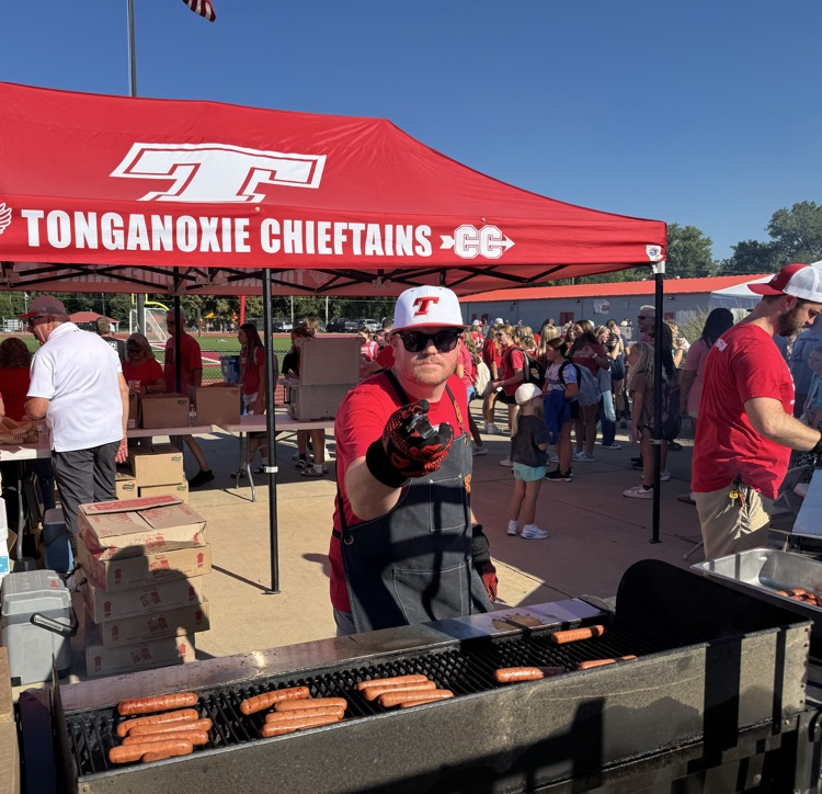 Matt bowers wear red t shirt, apron, an over mitt, and wielding tongs