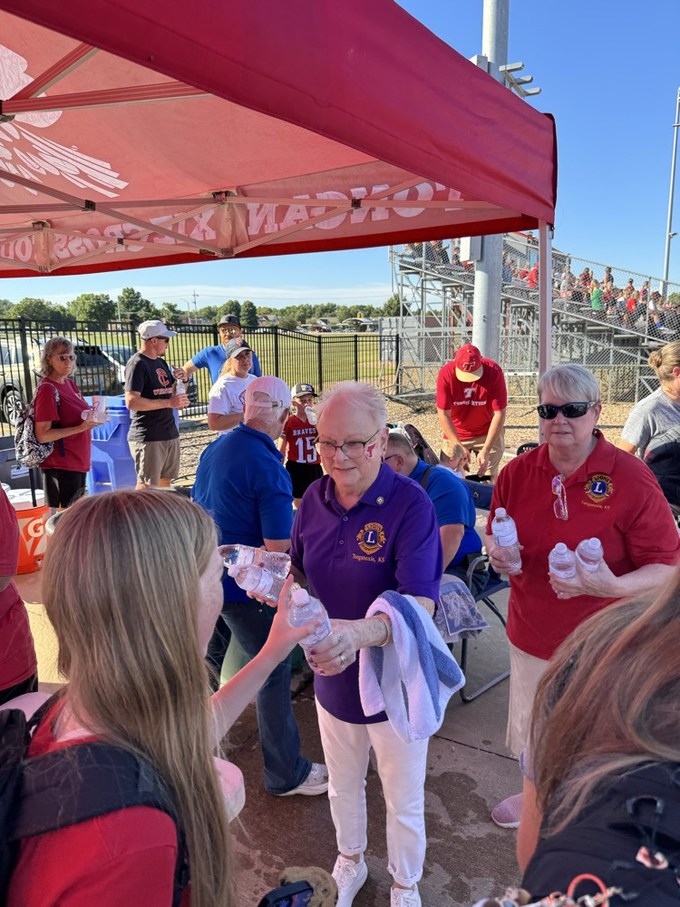 lions club members hand bottles of water to students and parents