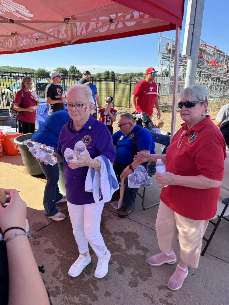 lions club members hand bottles of water to students and parents