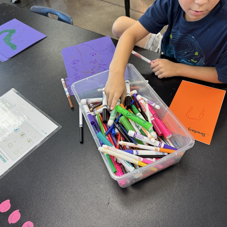 first graders drawing on sketchbook covers 