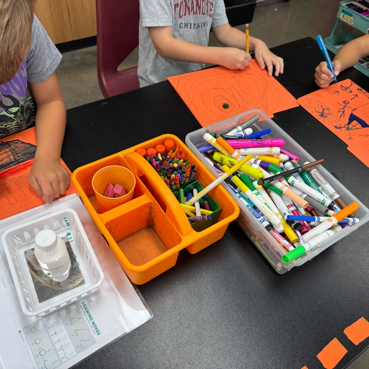 first graders drawing on folders