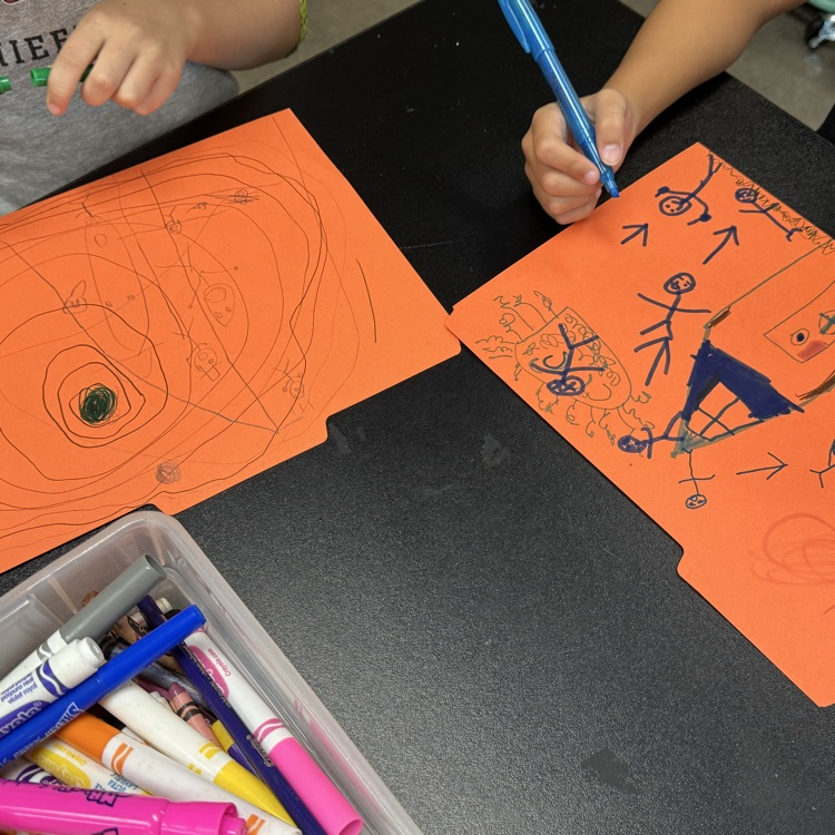 first graders drawing on folder