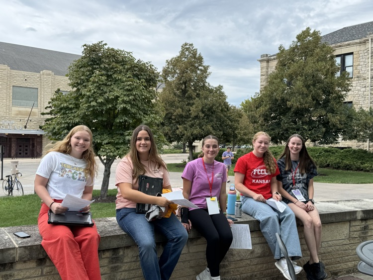 fccla members sitting on a brick wall on the campus of K State
