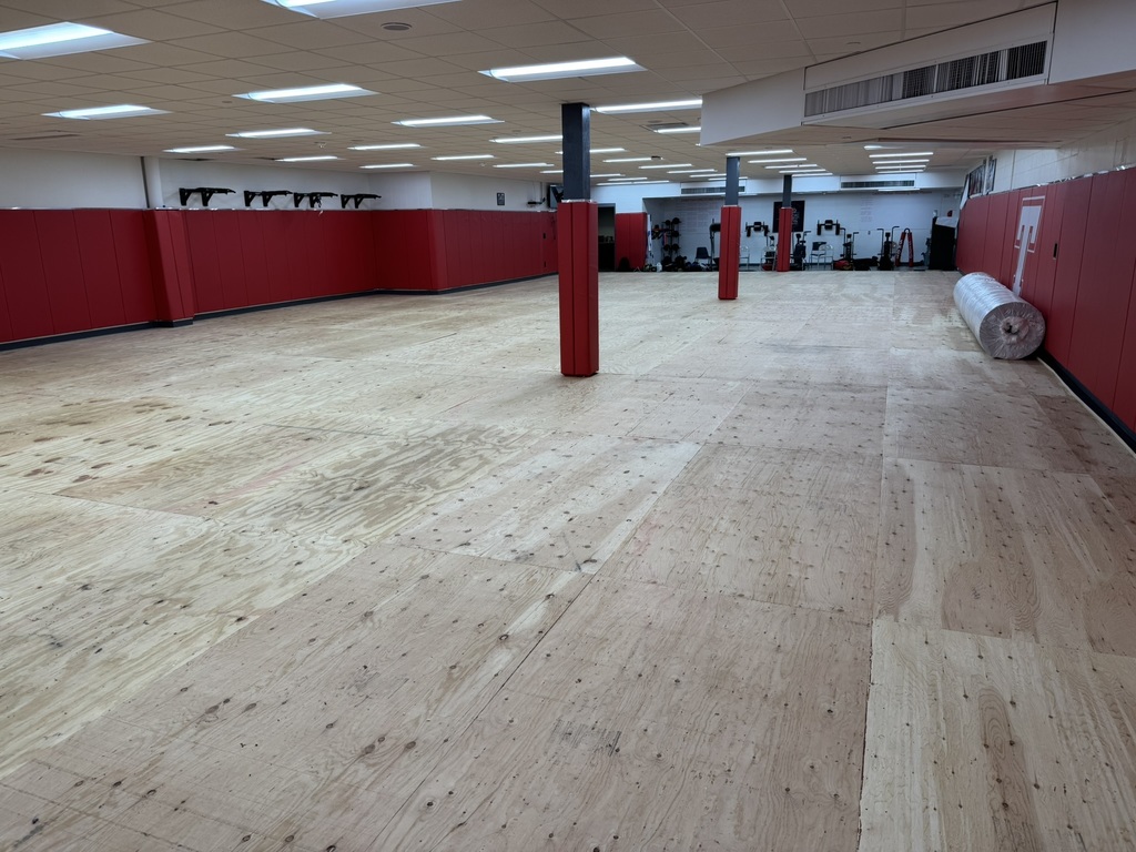 empty wrestling room with plywood floor